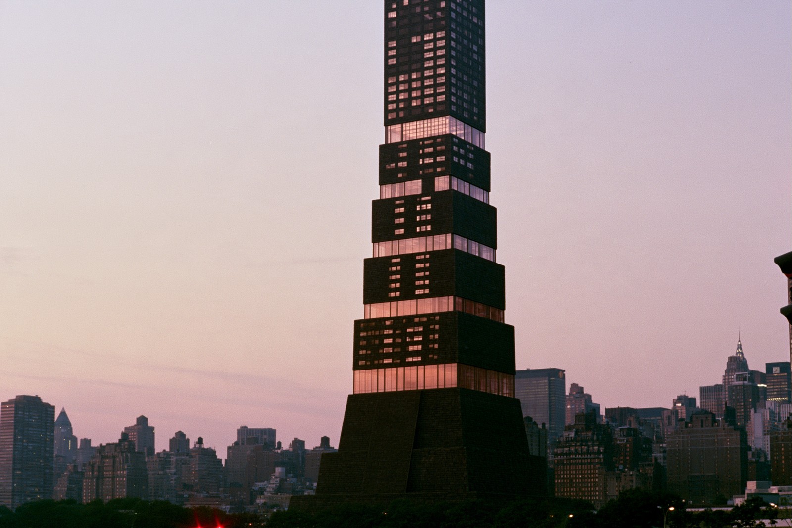 Mayan Stack high rise — Stacked dark stone frustums, a glass band per tier